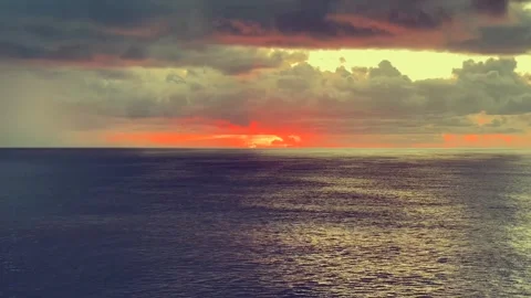 Dramatic sunset over a calm ocean with vibrant orange and red hues illumina.. Stock Footage 338280329