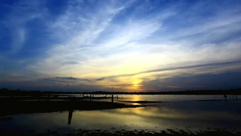 Dramatic Sunset over Calm Water with Cloudy Sky Stock Footage 310922951