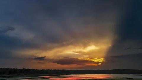 Dramatic sunset over calm water, showcasing vibrant colors reflecting on the 스톡 사진