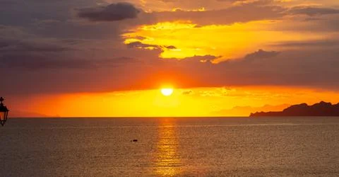 Dramatic Sunset Over Calm Water With Colorful Evening Sky Stock Photos
