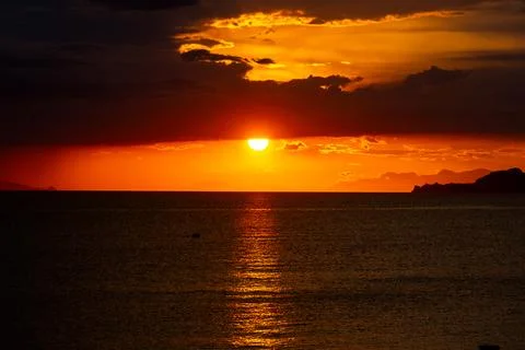 Dramatic Sunset Over Calm Water With Colorful Evening Sky Stock Photos