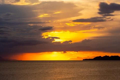 Dramatic Sunset Over Calm Water With Colorful Evening Sky Stock Photos