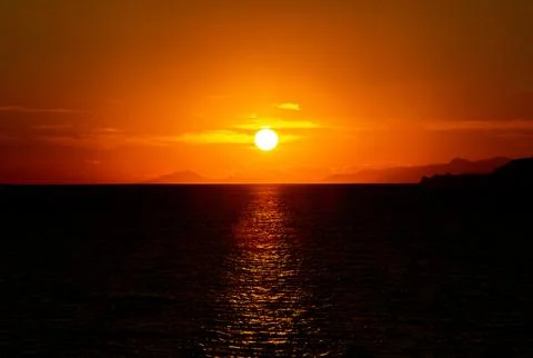 Dramatic Sunset Over Calm Water With Colorful Evening Sky Stock Photos