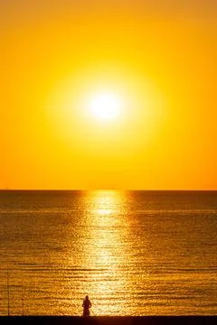 Dramatic Sunset Over Calm Water With Colorful Evening Sky Stock Photos