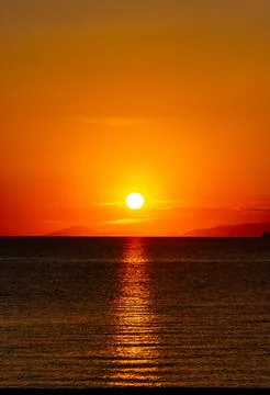 Dramatic Sunset Over Calm Water With Colorful Evening Sky Stock Photos