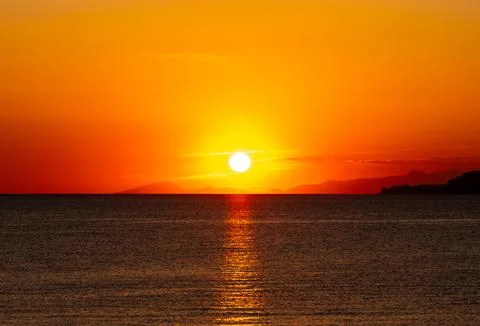 Dramatic Sunset Over Calm Water With Colorful Evening Sky Stock Photos