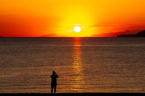 Dramatic Sunset Over Calm Water With Colorful Evening Sky Stock Photos