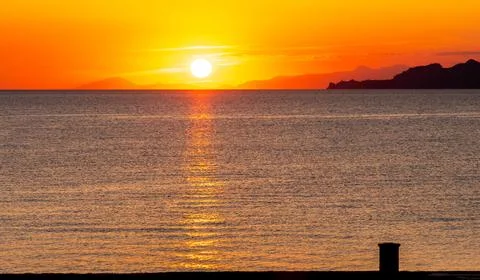 Dramatic Sunset Over Calm Water With Colorful Evening Sky Stock Photos