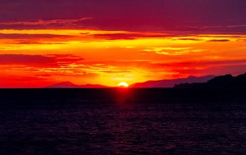 Dramatic Sunset Over Calm Water With Colorful Evening Sky Stock Photos