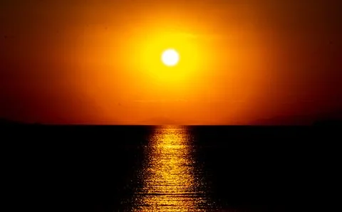Dramatic Sunset Over Calm Water With Colorful Evening Sky Stock Photos