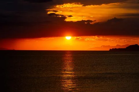 Dramatic Sunset Over Calm Water With Colorful Evening Sky Stock Photos