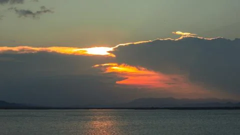 Dramatic Sunset Over Calm Water 写真素材
