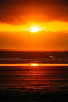 Dramatic sunset over dark Pacific ocean waves Stock Photos