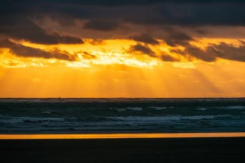 Dramatic sunset over dark Pacific ocean waves Stock Photos