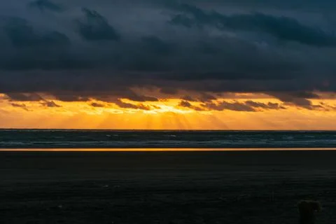 Dramatic sunset over dark Pacific ocean waves Stock Photos