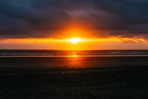 Dramatic sunset over dark Pacific ocean waves Stock Photos