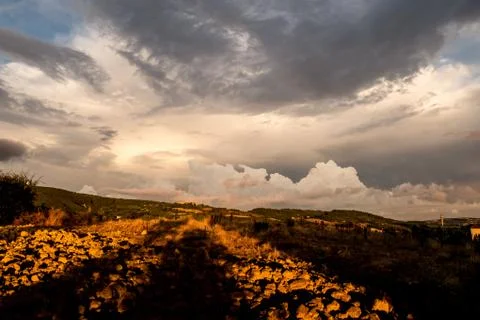 Dramatic sunset over a dry field, heavy clouds on a rural scene landscape Stock Photos