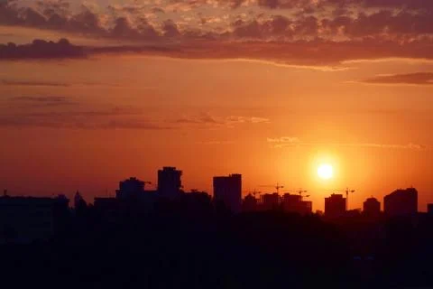 Dramatic sunset over the evening city. Stock Photos