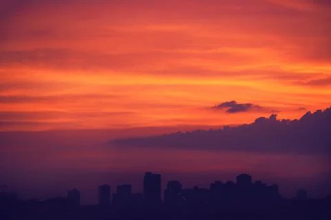 Dramatic sunset over the evening city. Stock Photos
