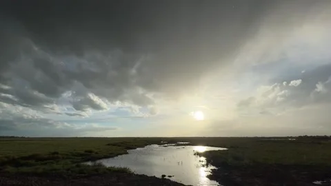 Dramatic Sunset Over Flat Wetland with Stormy Sky Xinjiang China Stock Footage 339172271
