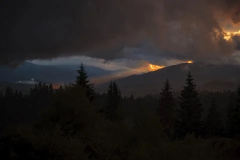 Dramatic Sunset Over Forested Mountains Stock Photos