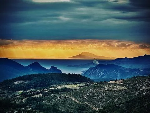 Dramatic sunset over Gökova Bay with mountain layers and stormy sky Turkey Foto stock