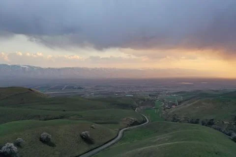 Dramatic Sunset Over Green Valley with Snow Mountains and Rural Village, Xi.. Stock Photos