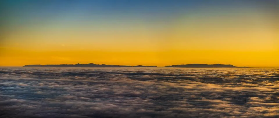 Dramatic sunset over islands emerging from a sea of clouds revealing Catalina Fotos de archivo