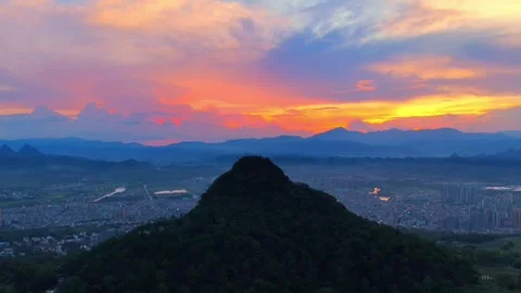 Dramatic Sunset Over Karst Mountain and Illuminated City Skyline Aerial View Stock-Footage 319726751