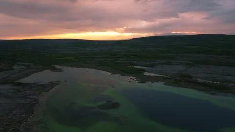 Dramatic Sunset Over Limestone Terrain and Reflective Waters in The Burren Stock Footage 336340363