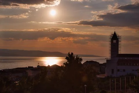 Dramatic sunset over  the Mediterranean sea with a church in the foreground i Stock Photos