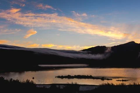 Dramatic sunset over a mountain lake Stock Photos