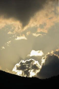 Dramatic sunset over mountain silhouette with vibrant clouds and golden rays Stock Photos