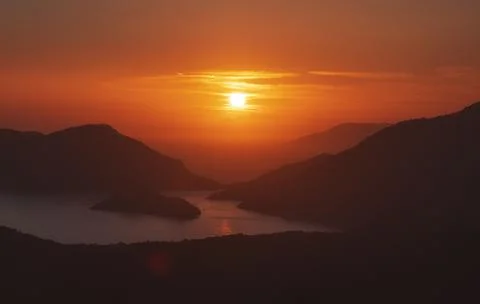 Dramatic sunset over the mountains and the sea 스톡 사진