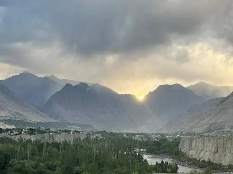 Dramatic sunset over mountains in Gilgit City with cloudy sky and river Stock Photos