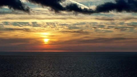Dramatic sunset over ocean with clouds reflecting golden light, cinematic f.. Stock Footage 337448115