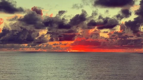 Dramatic sunset over the ocean with colorful clouds reflecting on calm water Stock Footage 338281950