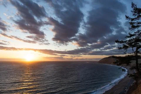 A dramatic sunset over the ocean with colorful skies Stock Photos