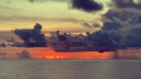 Dramatic sunset over the ocean with dark clouds creating a vivid and colorf.. Stock Footage 338282221