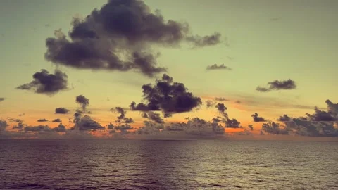 Dramatic sunset over the ocean with dark clouds creating a striking contras.. 動画素材 338282648