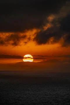 Dramatic sunset over the ocean with fiery orange clouds and dark sea Fotos de archivo