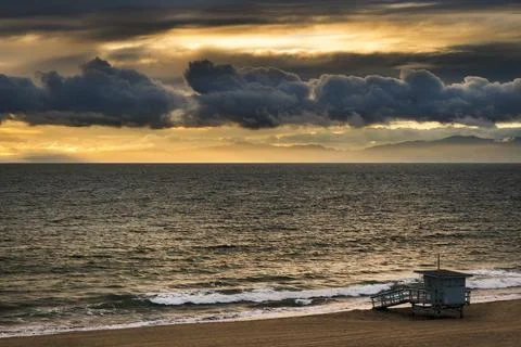 Dramatic sunset over the ocean with a lifeguard tower on a sandy beach Fotos de archivo