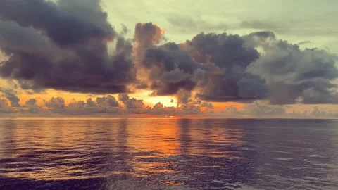 Dramatic sunset over the ocean with scattered clouds reflecting golden ligh.. 動画素材 338282749