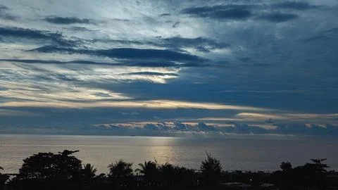 Dramatic Sunset Over the Ocean with Silhouetted Trees 2 Photos