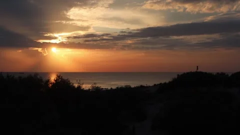 Dramatic sunset over ocean with sunbeams through clouds. Landscape of Stock Footage 322095288