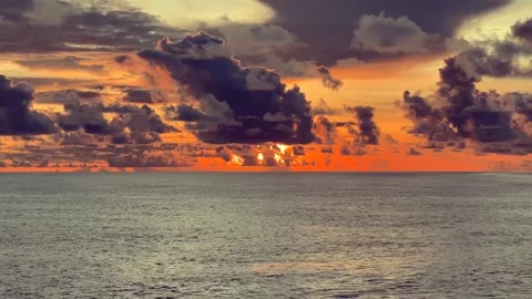 Dramatic sunset over the ocean with vibrant orange and yellow hues in the s.. 動画素材 338280336
