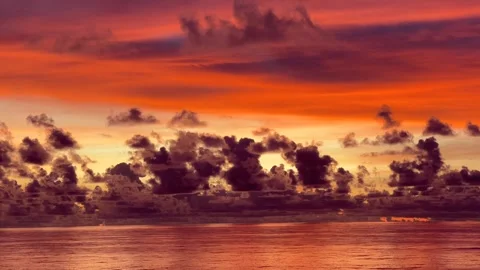 Dramatic sunset over the ocean with vibrant orange clouds reflecting on the.. Stock Footage 338282734