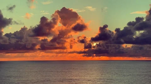 Dramatic sunset over the ocean with vivid orange and pink clouds reflecting.. Stock Footage 338281976