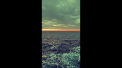Dramatic sunset over ocean waves with cloudy sky creating a tranquil and se.. Stock Footage 338279847