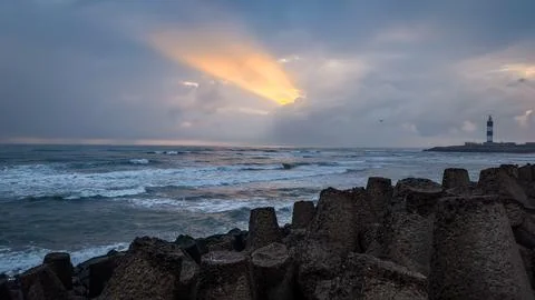 Dramatic Sunset Over Ocean Waves Beneath Dark Monsoon Clouds Stock Photos
